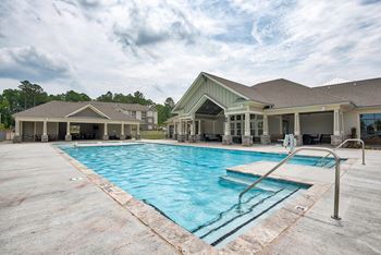 Resort-style pool with tanning shelf and sun deck